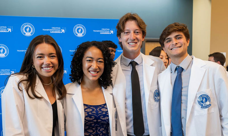 White Coat Cerempony Four new students in white coats pose for a photos after their White Coat Ceremony at NEOMED