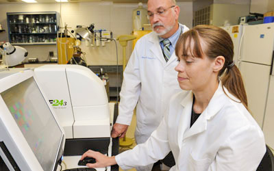 HBV_lab-1-2 Two researchers in NEOMED's Heart and Blood Vessel Disease Research Focus Area prepare a test related to heart disease.