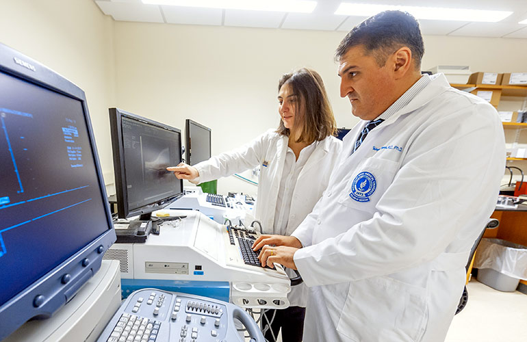 Two researchers in white coats work in NEOMED's REDIzone space in the Greater Cleveland area.